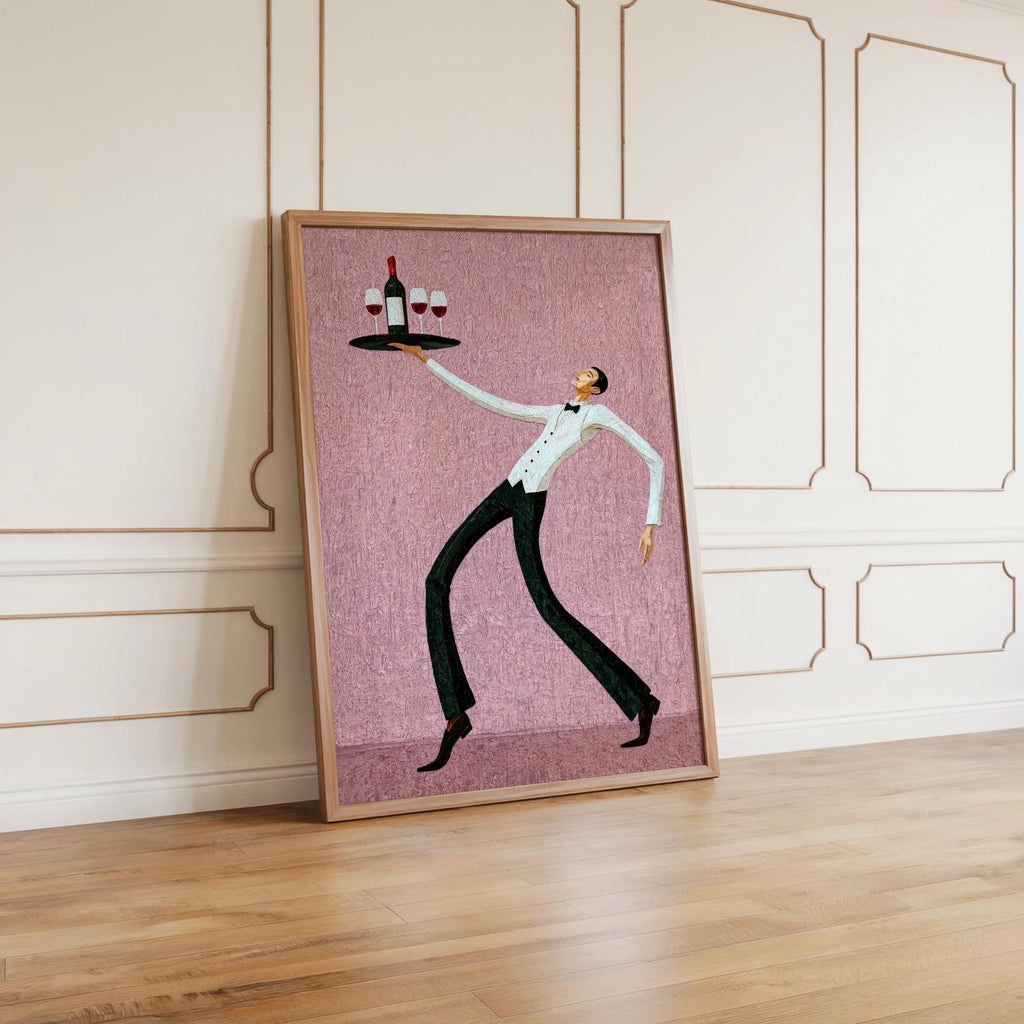 Dusty pink wine waiter art print leaned against paneled wall on hardwood floor, playful restaurant wall decor for home bar areas