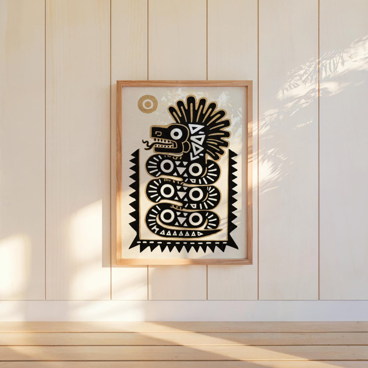 Quetzalcoatl art print propped against white paneled wall, minimal stool and soft side-lighting, tribal feel