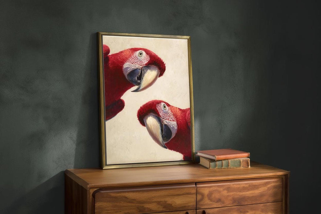 Scarlet macaw art print angled on a wooden dresser, moody green wall, vivid painterly red feathers visible