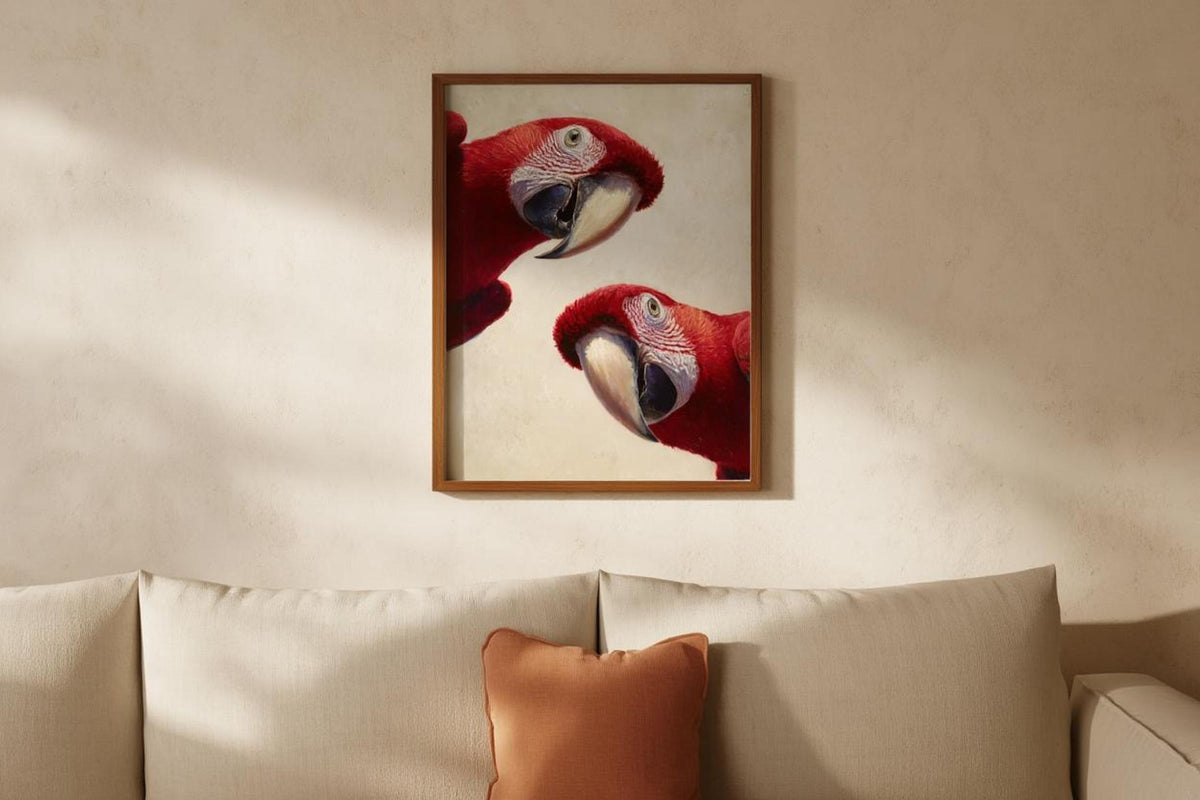 Tropical bird wall decor hung above a sofa, clean modern room styling, red macaws on warm cream texture