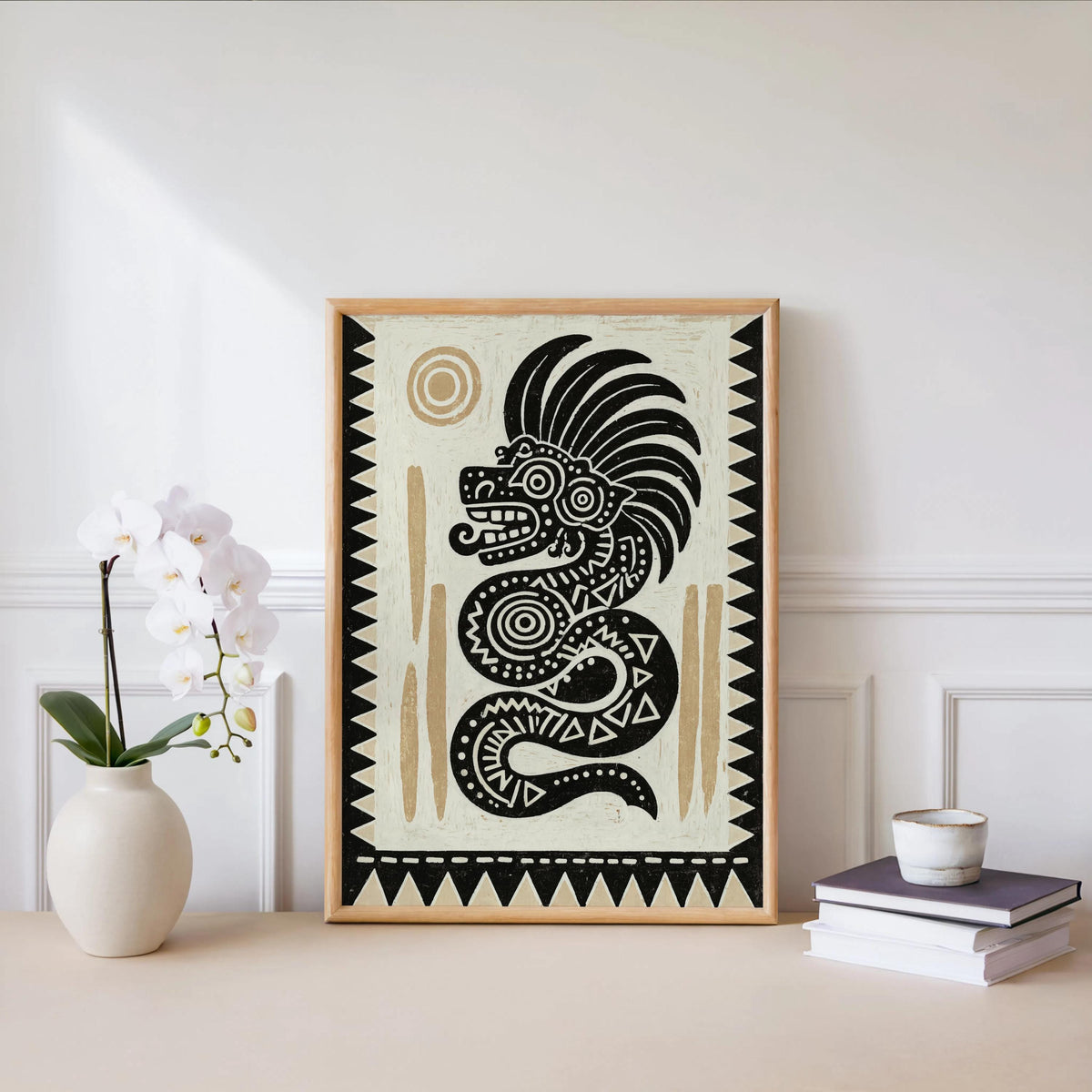 Quetzalcoatl art print centered on a wall, paired with orchid and cup, neutral Latino wall art styling.