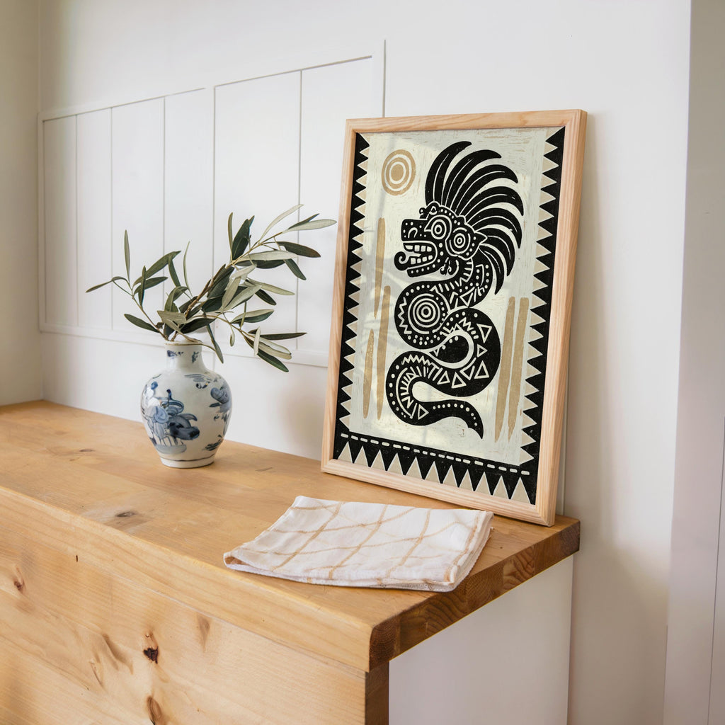 Serpent illustration print leaned against a light wood cabinet, Mexican cultural art vibe with ceramic vase.
