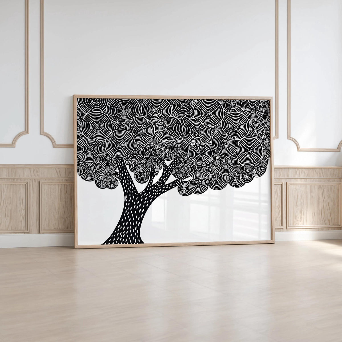 Large black and white tree wall art leaning on floor against molding, linocut tree print statement piece