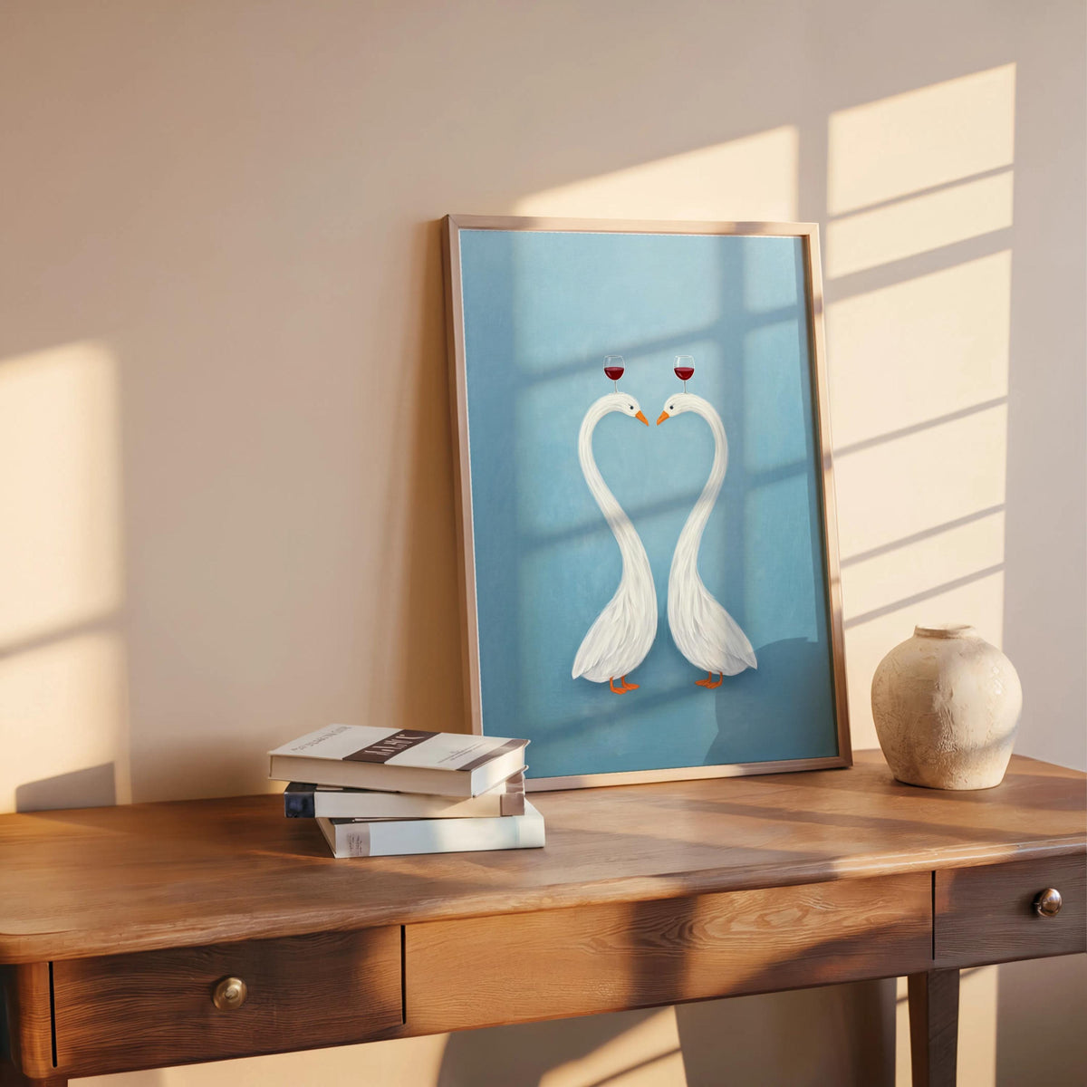 Blue romantic swan wall art leaning on table, framed poster with ceramic vase and books, clean minimalist vibe