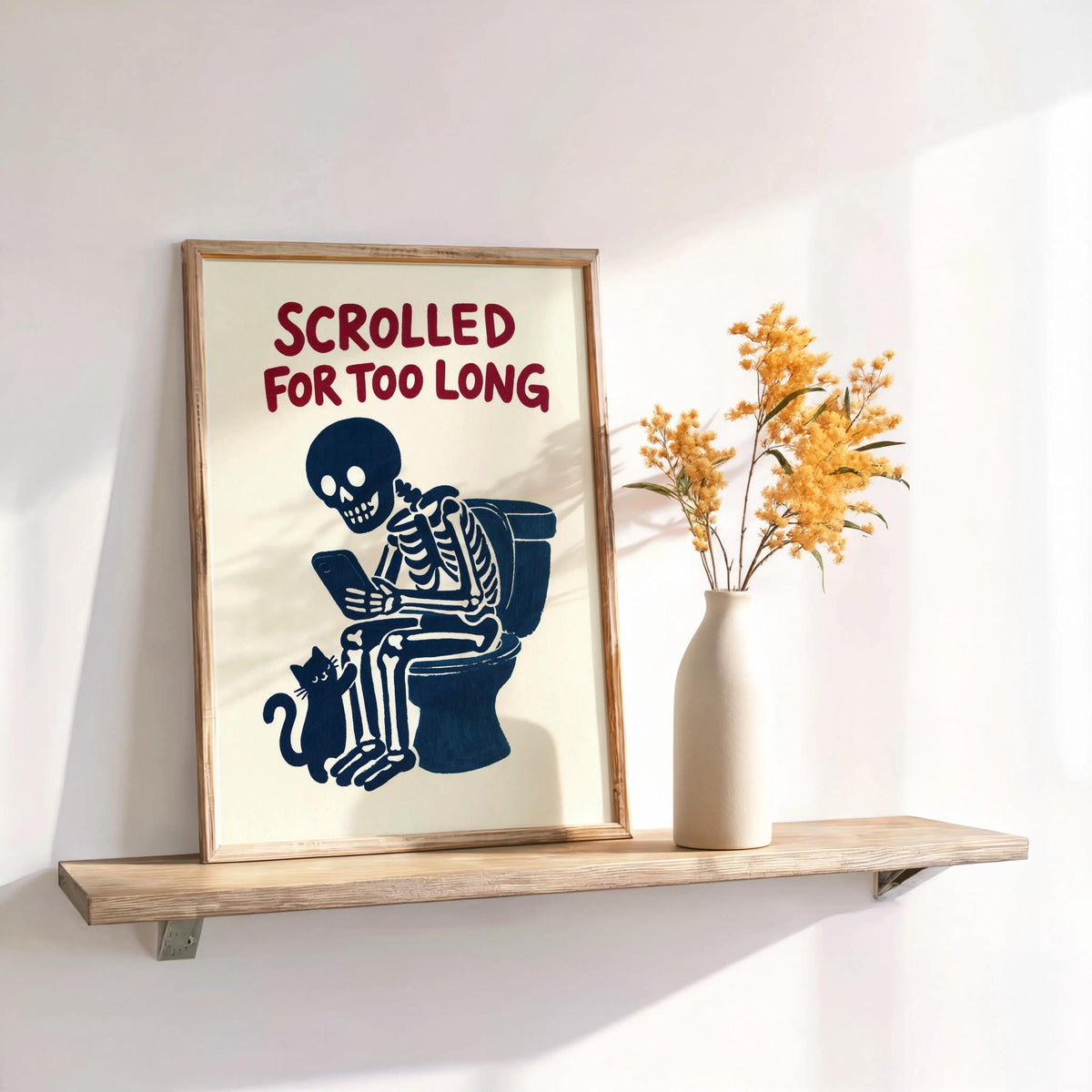 Small print on floating shelf, retro cream poster with dark red Scrolled for Too Long text, navy skeleton