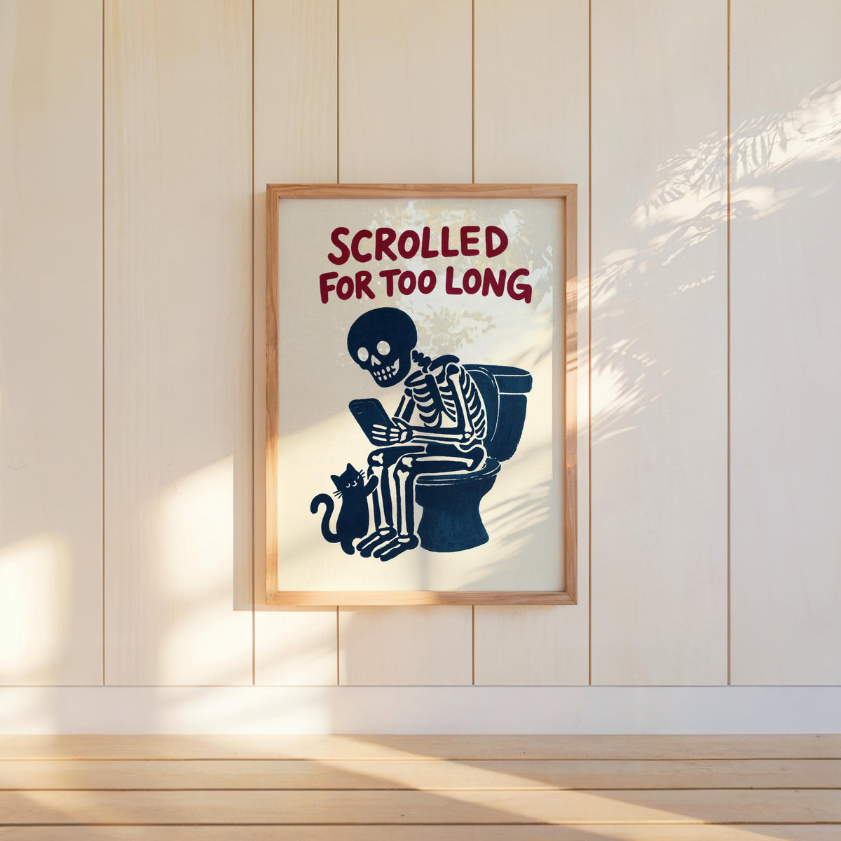 Wall-hung funny bathroom wall art, skeleton on toilet and cat, warm paneled cream wall lighting