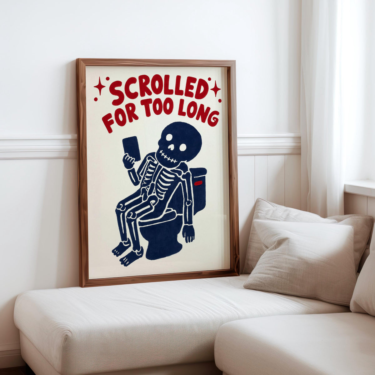 Funny skeleton bathroom art propped on a sofa cushion, creepy cute skeleton art with bold red distressed typography