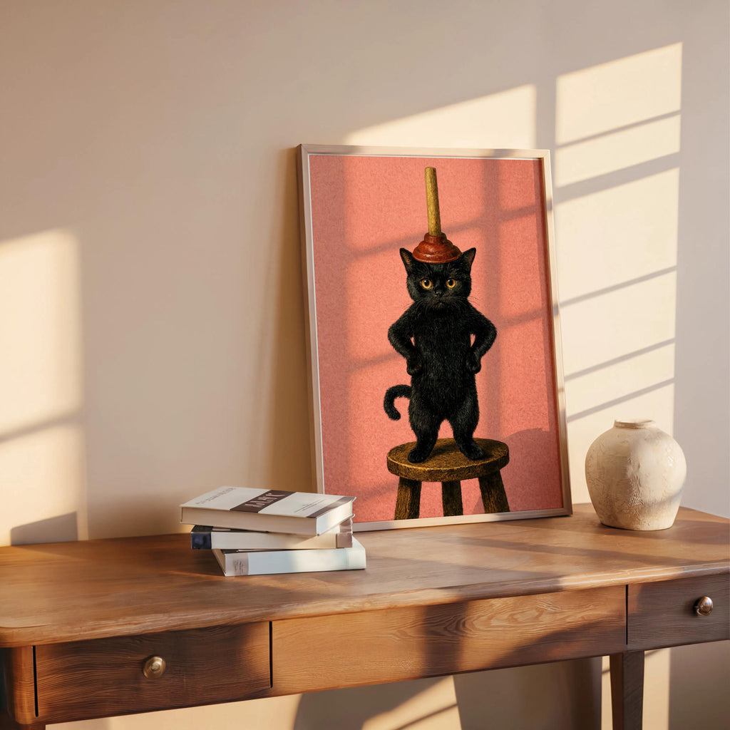 Leaning funny black cat bathroom art print, soft pink background, playful plunger cat showcased on rustic table