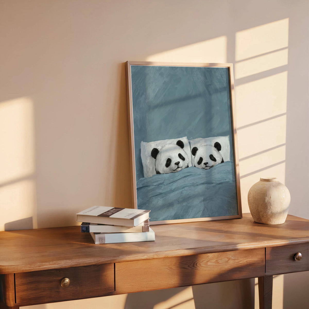 Blue sleeping panda wall art on a desk next to books, soft sunlight, cute animal poster suited for nursery or bedroom