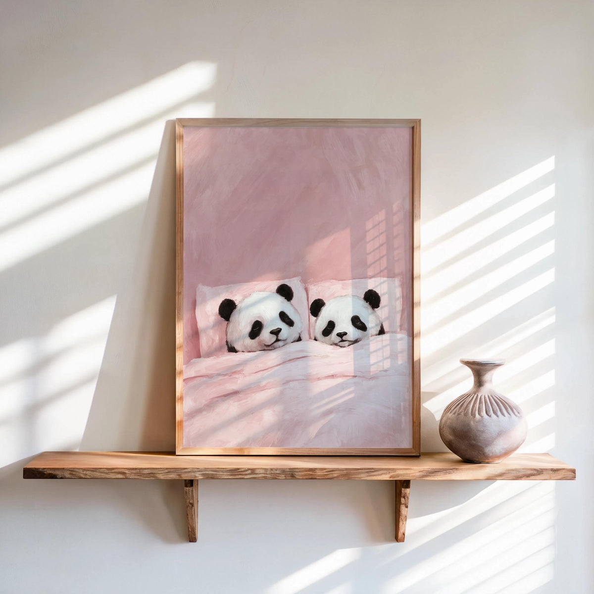 Blush pink sleeping panda wall art, framed on a wooden shelf with a vase, sunlit striped shadows, cuddling panda print