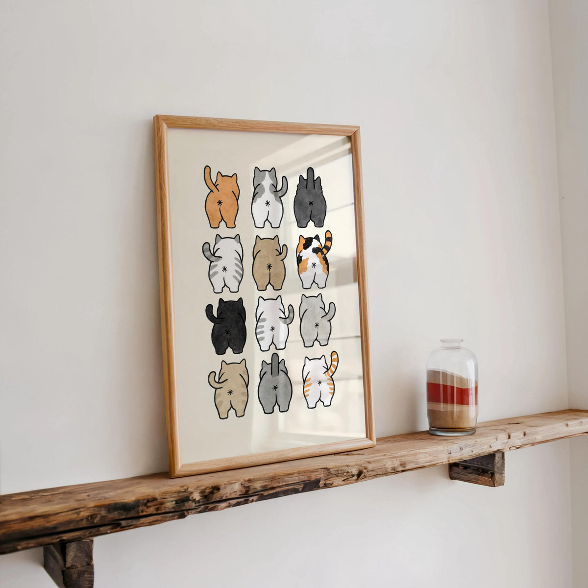 Wood-framed print on a rustic shelf with candlelight, playful cat butt art, works as funny kitty toilet art or gag gift