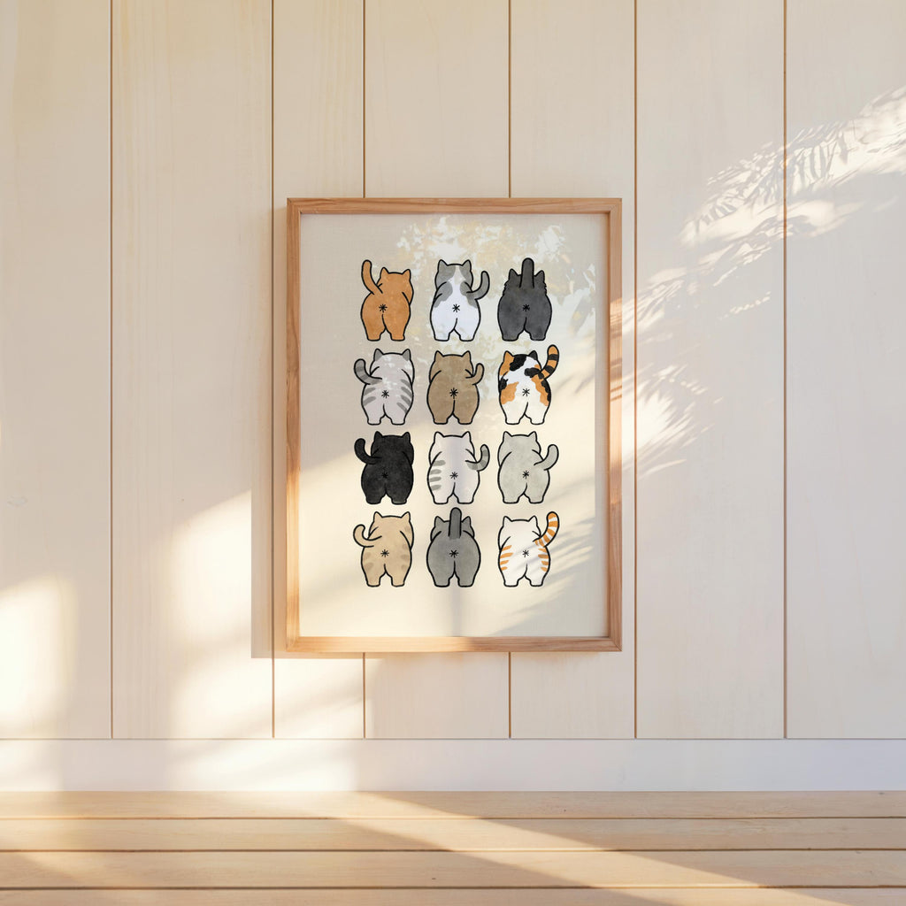 Hanging wooden frame on painted panels, morning light on cute watercolor cat butt art print for bathroom