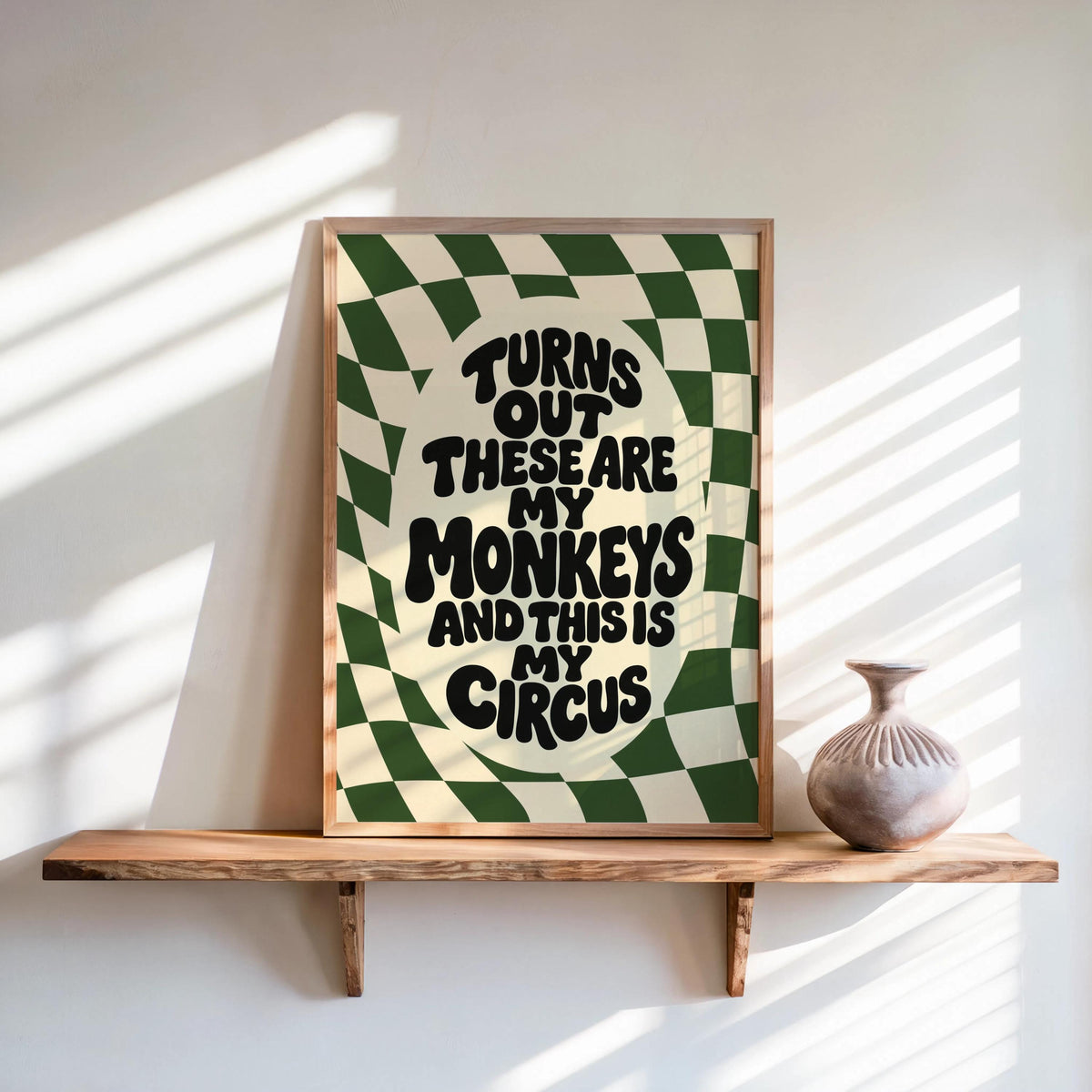 Green dopamine decor wall print propped on wood shelf, wavy text and checkerboard, not my circus not my monkeys wall art