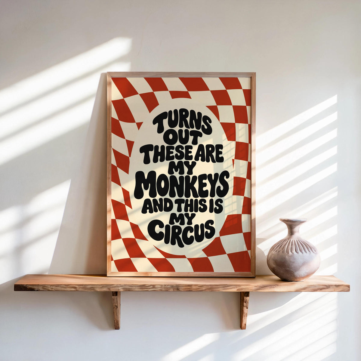 Framed red groovy checkerboard art print on a shelf, bold wavy type, not my circus not my monkeys wall art