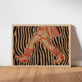Unframed cowgirl wall art print leaning on wood floor, red cowgirl figure over zebra black and cream stripes