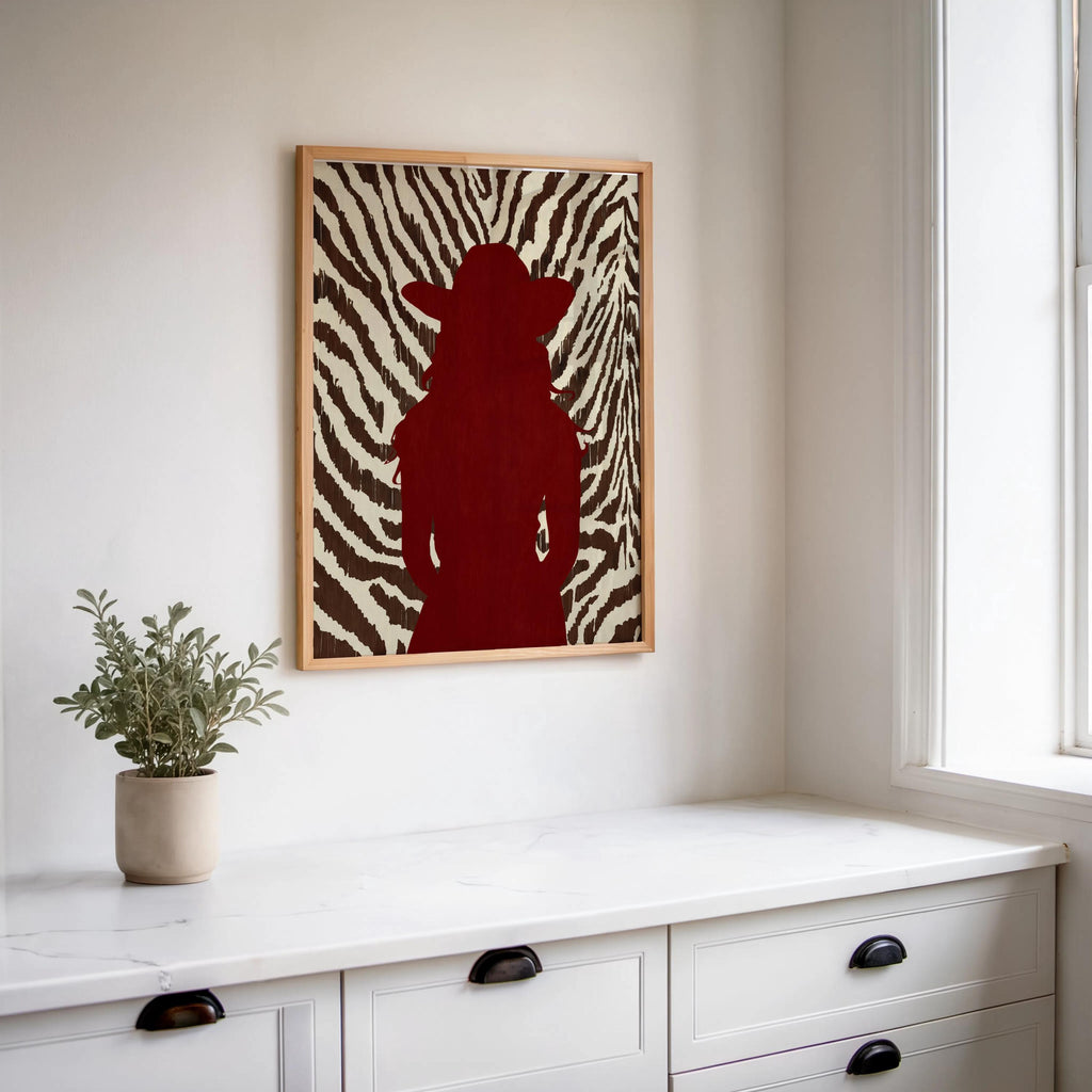 Console vignette with framed western cowgirl wall decor, red silhouette and zebra stripes for boutique styling