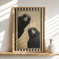Framed vintage crow wall art leaning on a wood shelf, warm beige backdrop, bold black-and-cream striped border