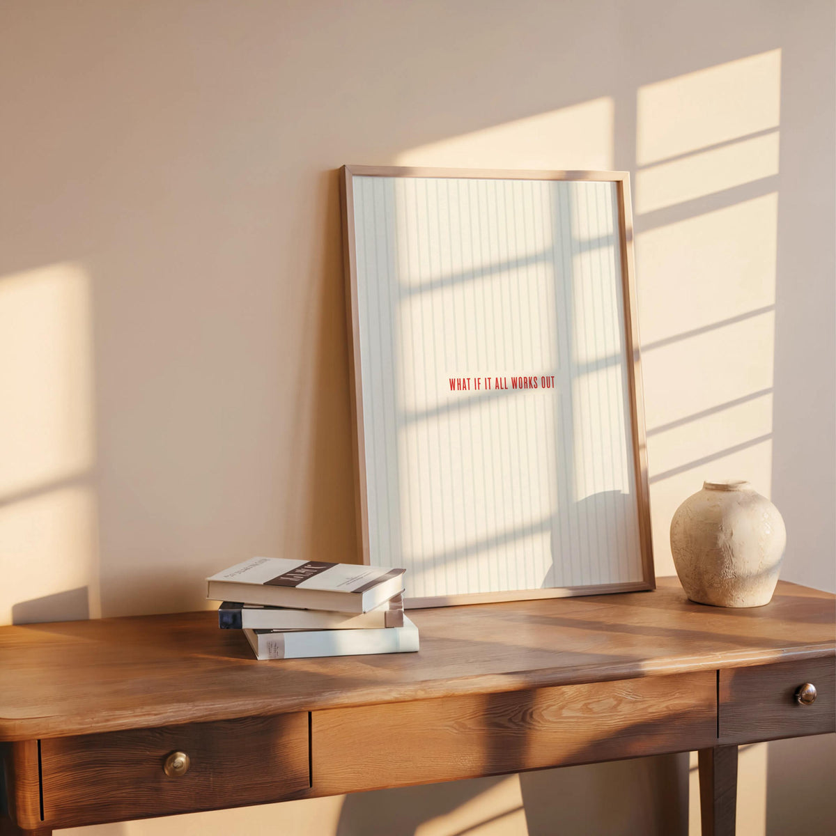 Desk styling with what if it all works out motivational wall art, stacked books and ceramic vase