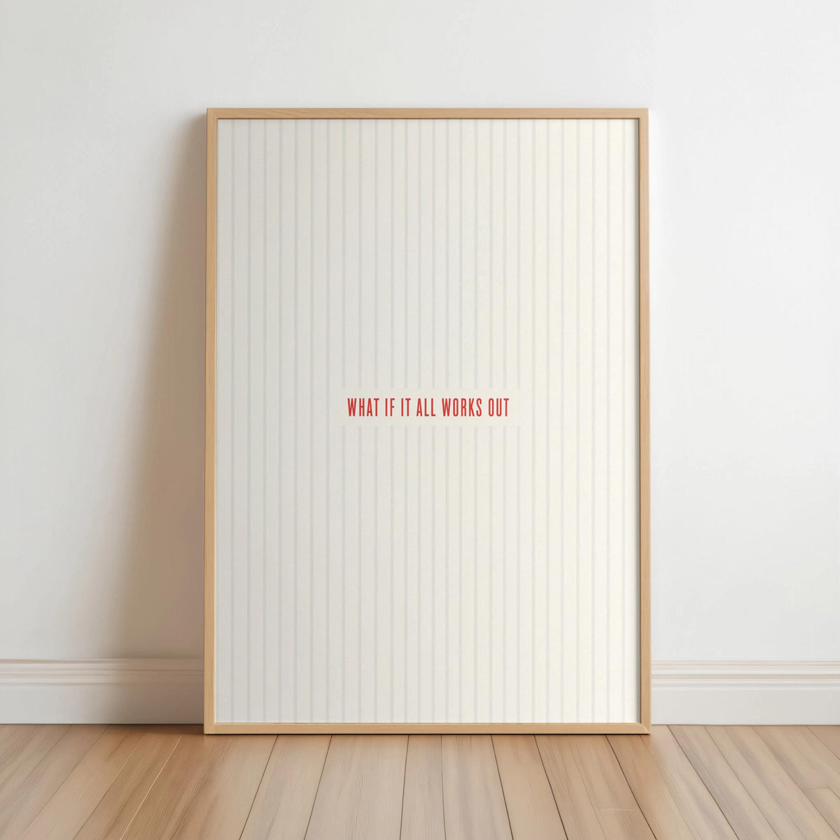 Light wood framed what if it all works out wall art leaning on floor, cream stripes, red type