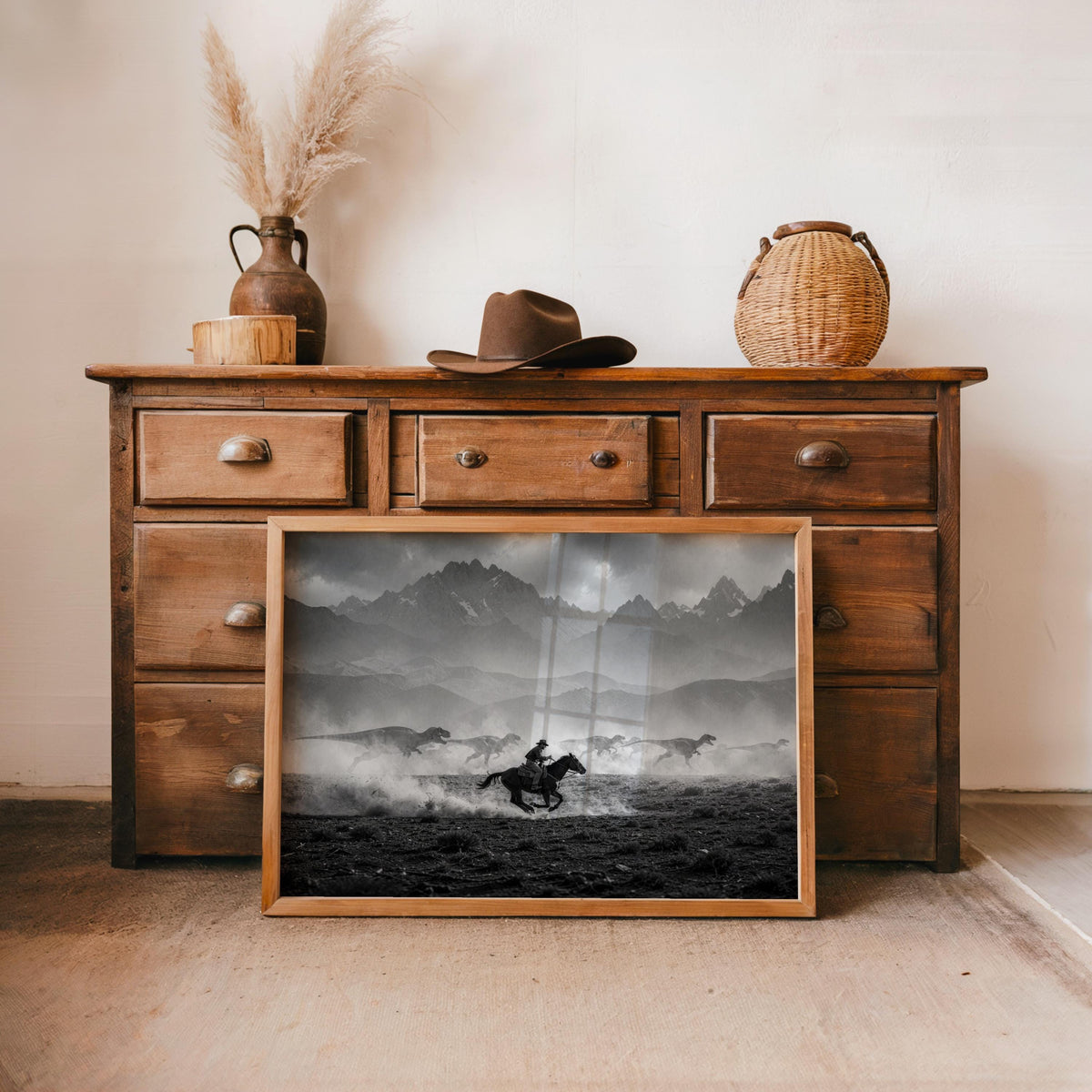 Rustic dresser staging with cowboy dinosaur wall art, moody clouds, archival paper print framed