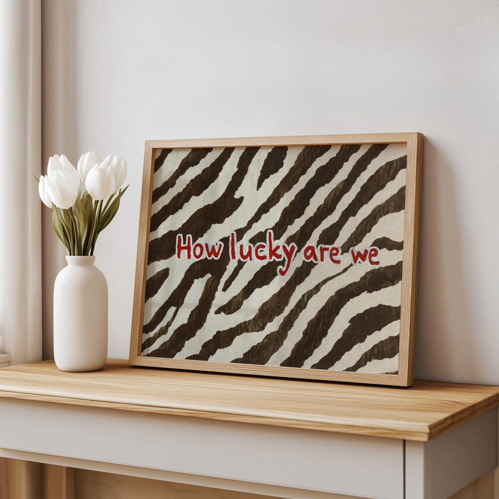 Personalized zebra print wall art in frame on console with white vase, brown and cream animal print backdrop