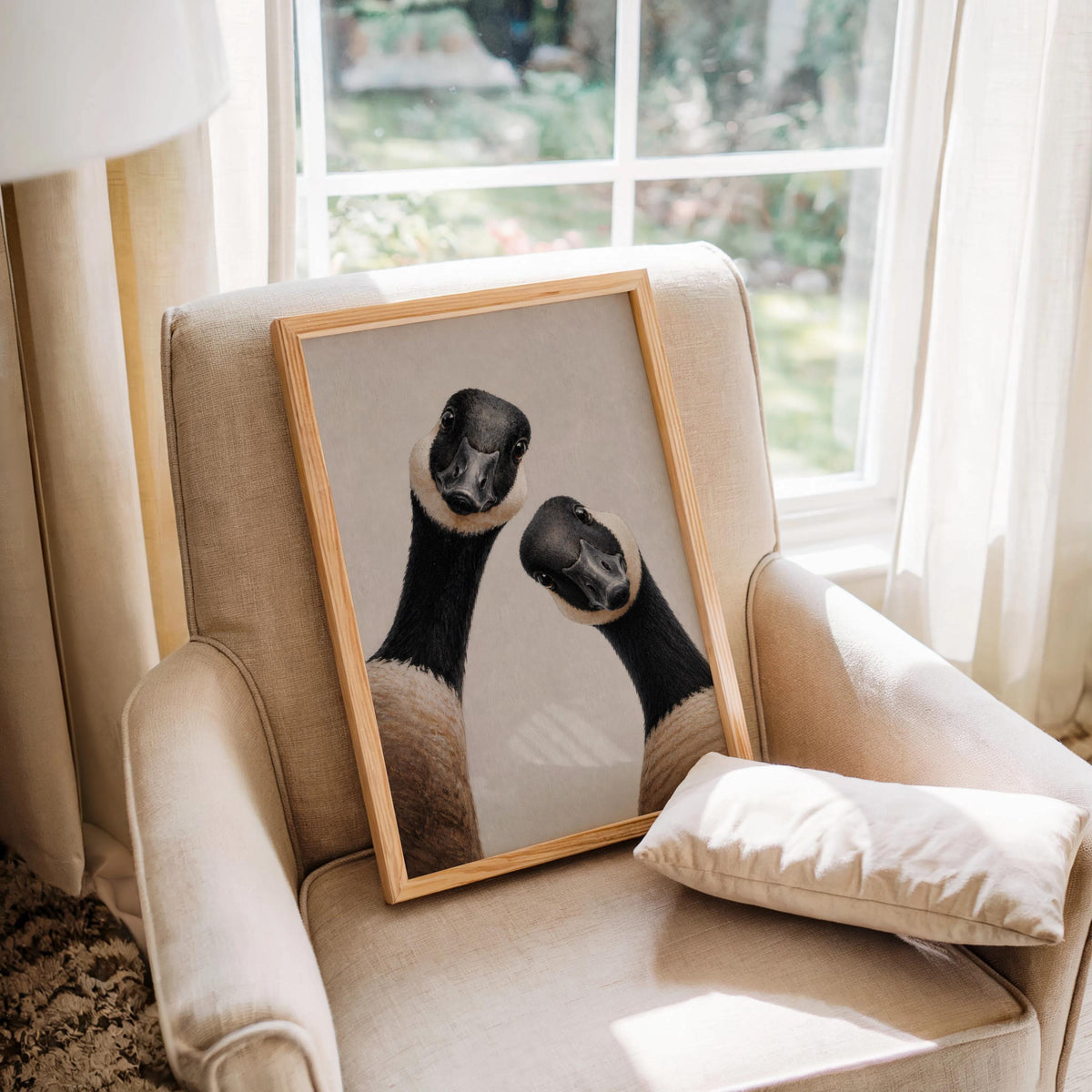 Canadian geese wall art leaning on a cozy armchair by a sunny window, natural frame, cottage home decor