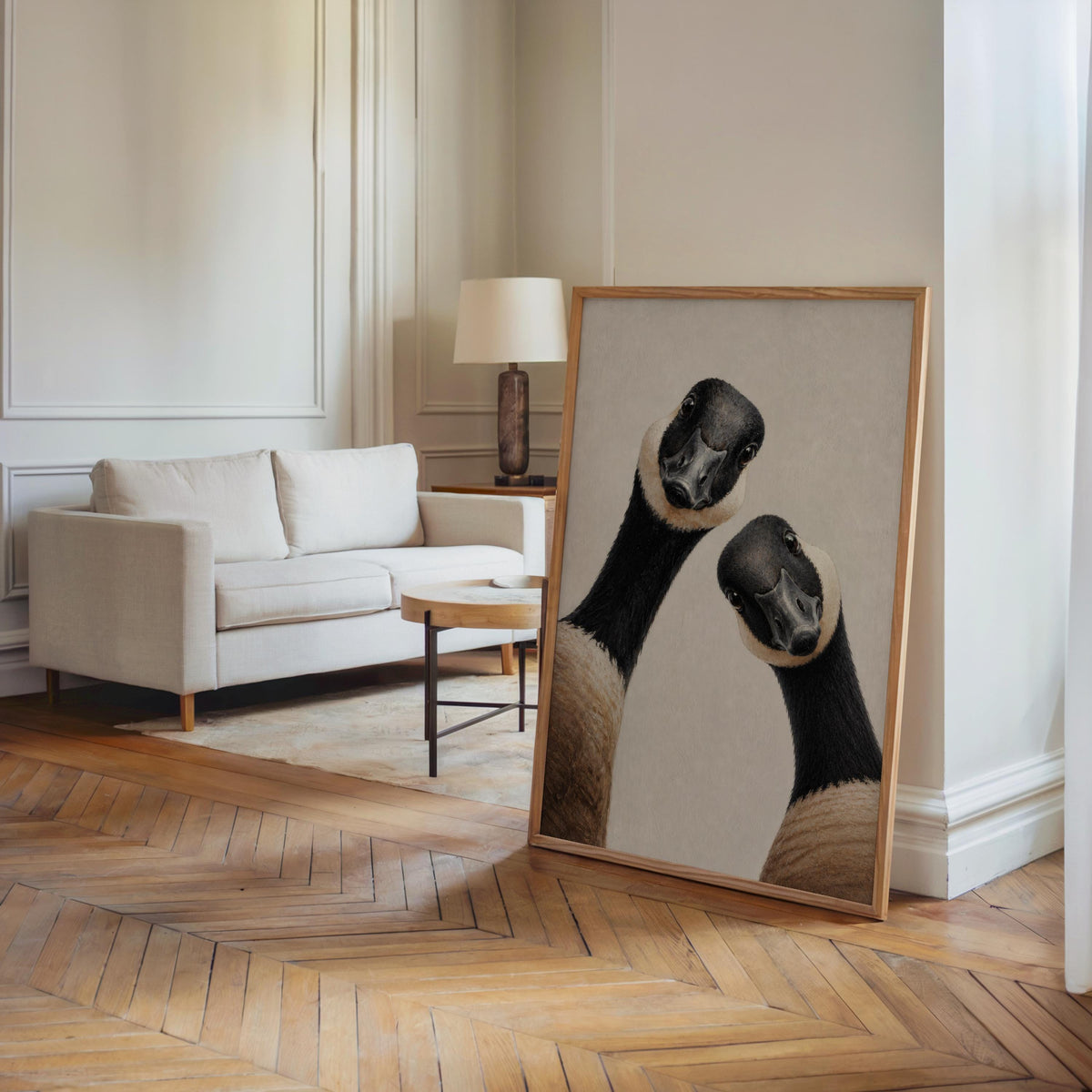 Large Canadian geese wall art print leaning on a hardwood floor in a living room, cabin vibe