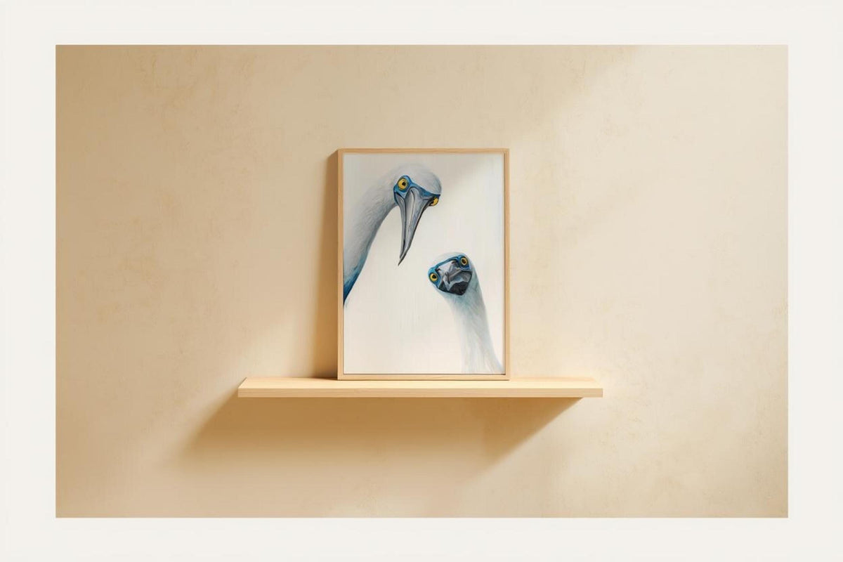 Framed print perched on narrow shelf against warm beige wall, quirky kitchen wall art mood, blue footed booby wall art print