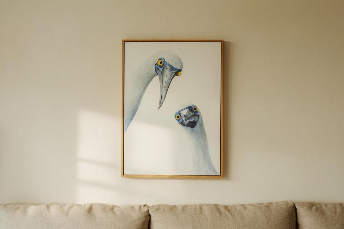 Wall-hung light wood frame at eye level in a warm room, humorous blue-footed booby expressions, blue footed booby wall art print