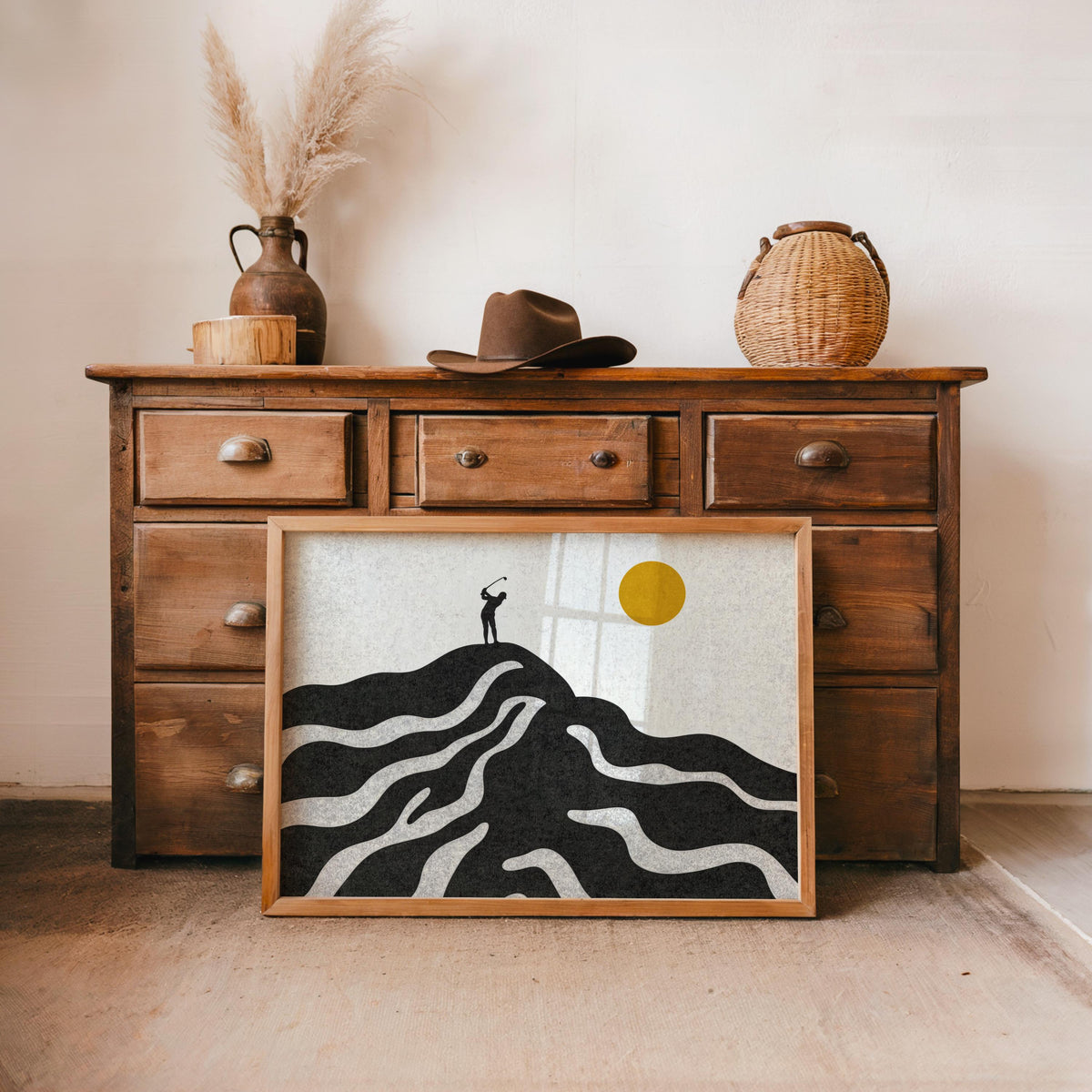 Black mid century golf art print styled under a vintage dresser, warm cream background, yellow sun peeking