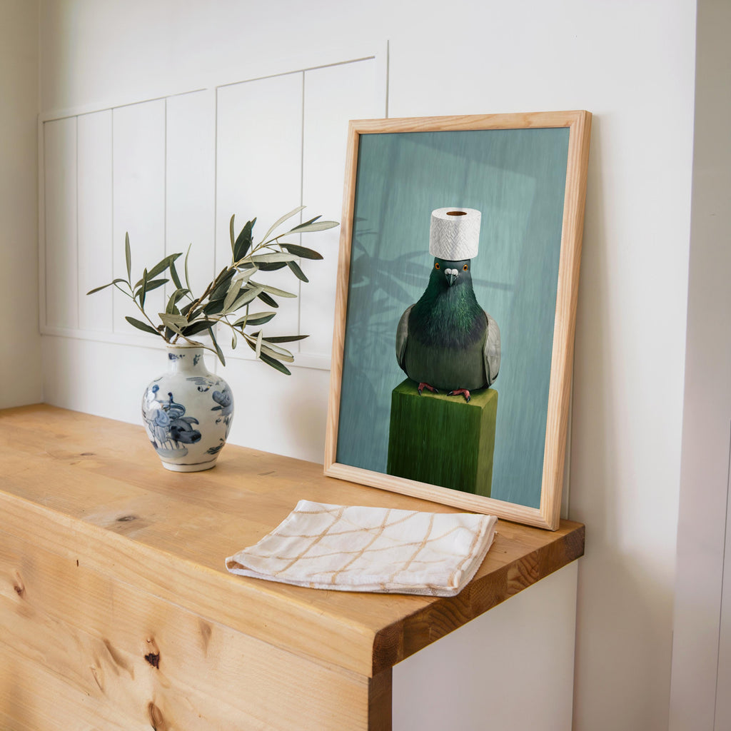 Pigeon print styled on a wooden desk with a ceramic vase, quirky pigeon wall decor, subtle muted color palette