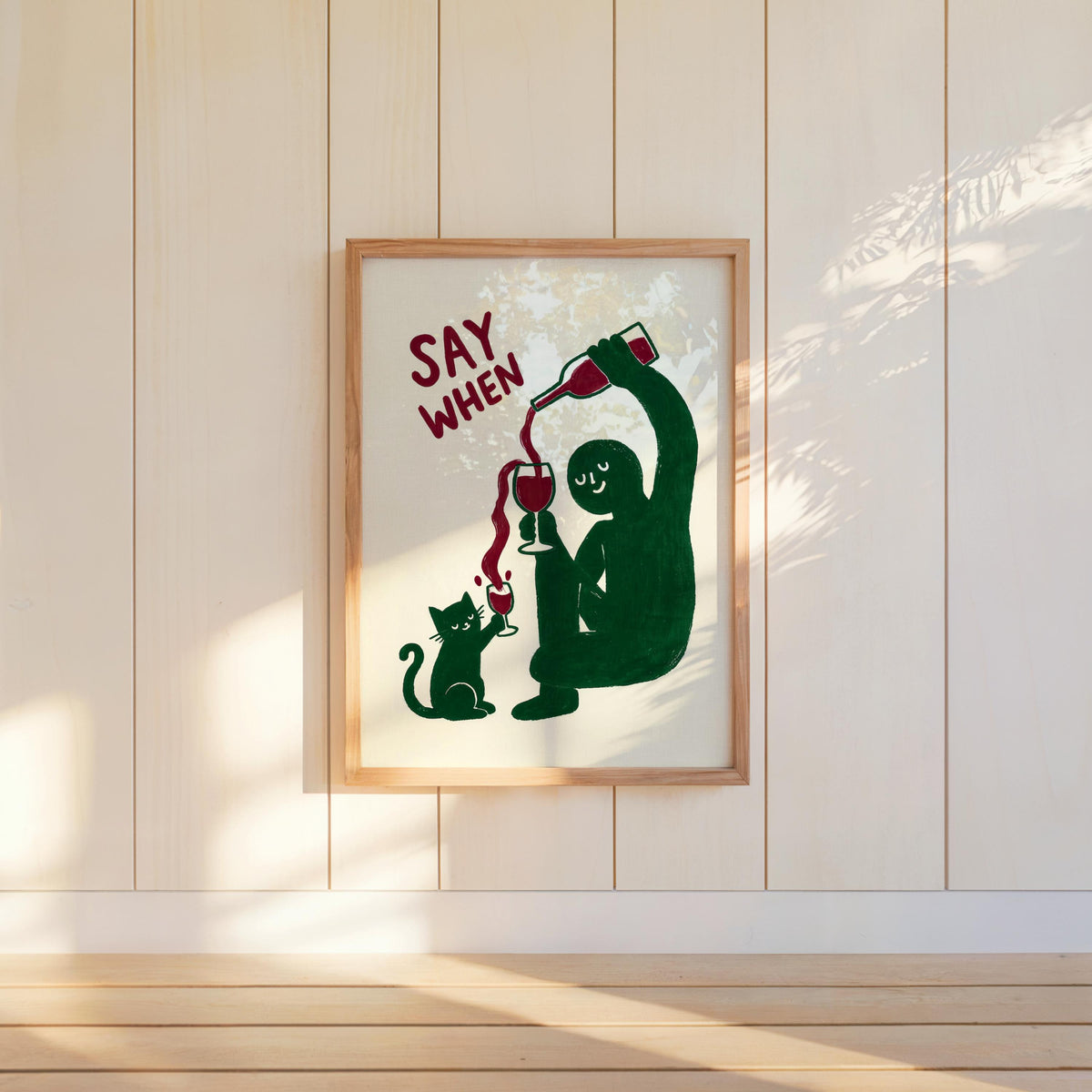 Wall-hung green SAY WHEN poster on white paneling, bright sun highlights and slight texture, quirky dining room decor, funny cat wine wall art