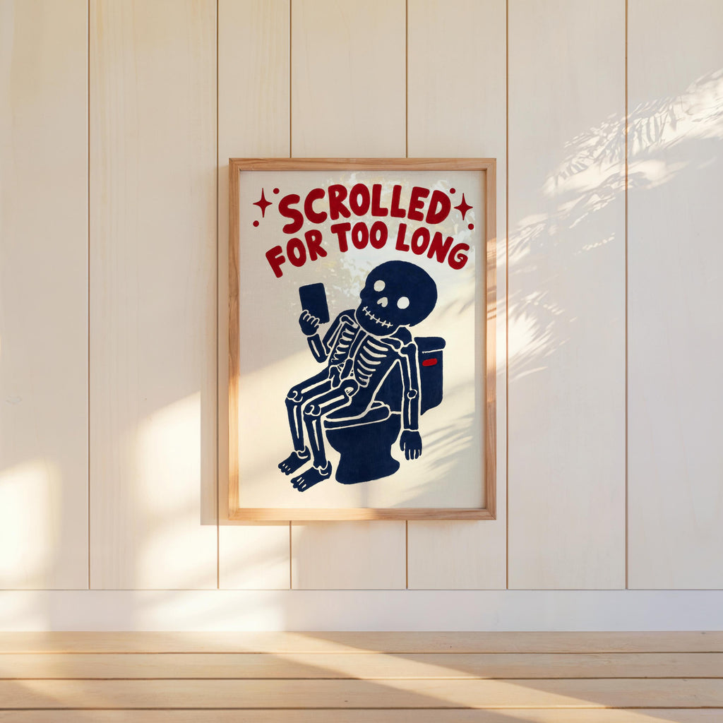 Funny skeleton bathroom art hung on paneled wall, sunlit cream background, distressed red SCROLLED text