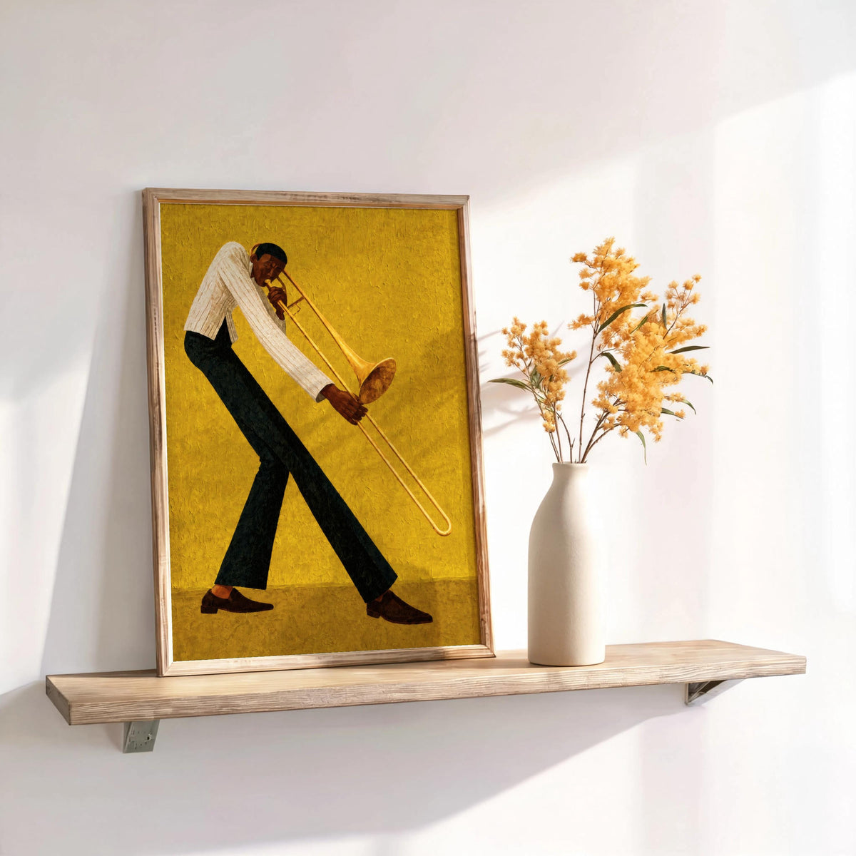 Jazz trombone wall art, ochre print leaning on shelf with ceramic vase, styled retro music room decor.