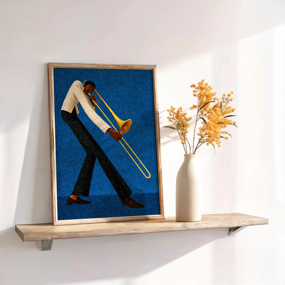 Jazz trombone wall art, deep blue framed print on shelf with dried stems, music room decor styling.