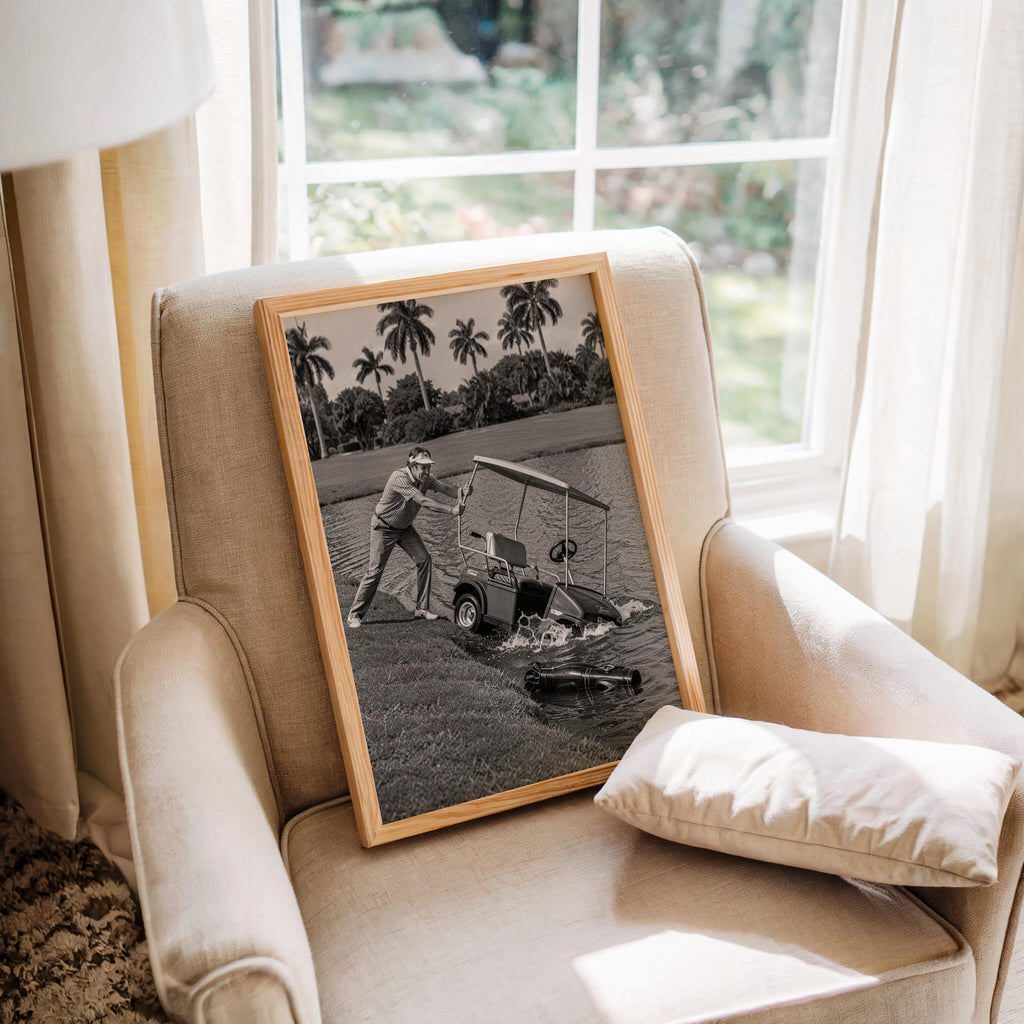Angry golfer poster in wood frame mockup on a cozy armchair by a window, retro sports art.