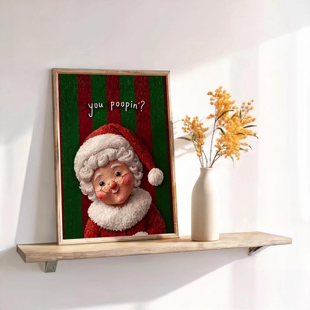 Wide shelf display with framed green-and-red Mrs Claus print and vase, nostalgic gag, funny Christmas bathroom wall art