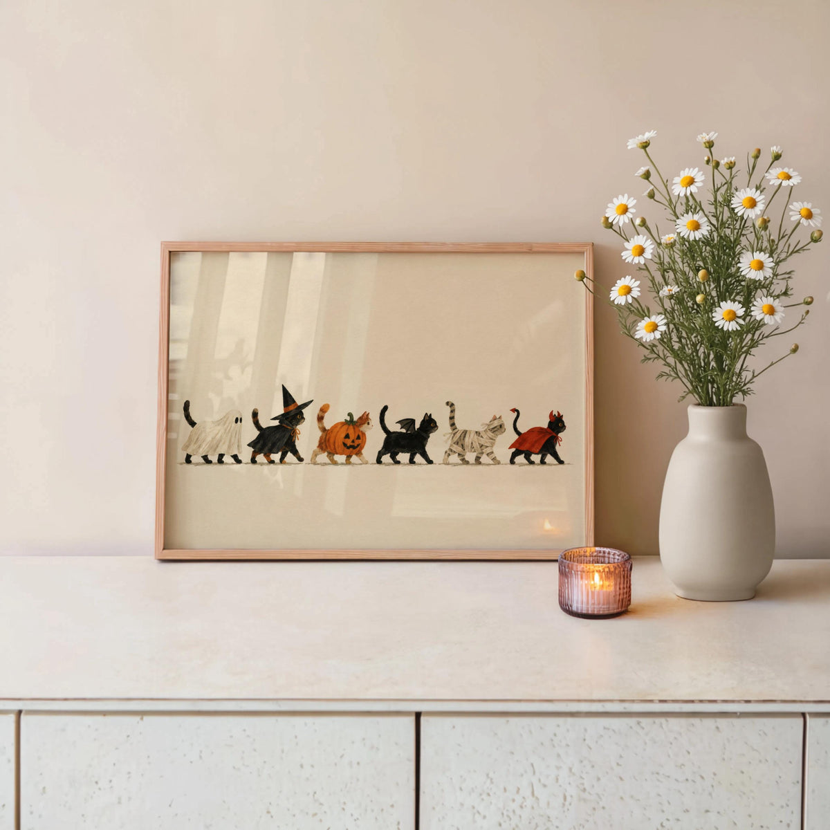Framed Halloween cat wall art on sideboard with daisy vase, vintage illustration, autumnal palette
