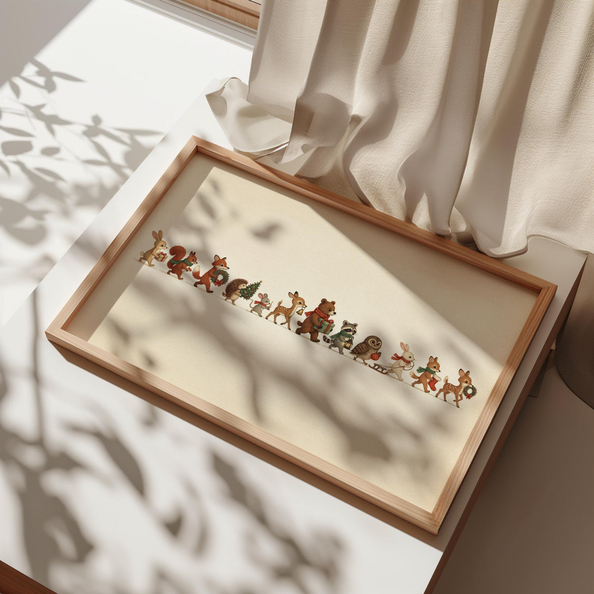 Angled frame on floor by curtains, framed Christmas woodland animals print in dappled sunlight, rustic mood