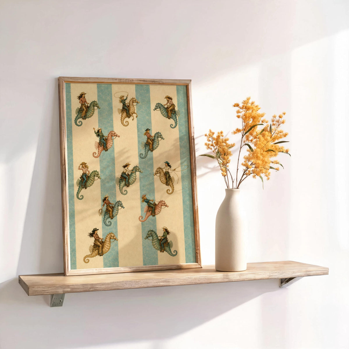 Vertical coastal cowgirl print in a light wood frame on a shelf, soft aqua and muted coral seahorse stripes