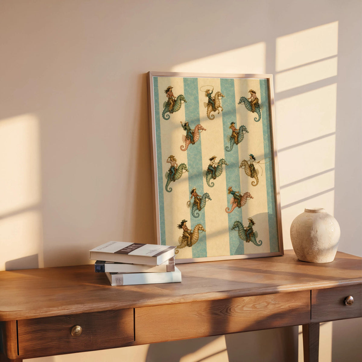 Coastal cowgirl print styled on a wood desk with books and pottery, warm morning light highlights seahorse design