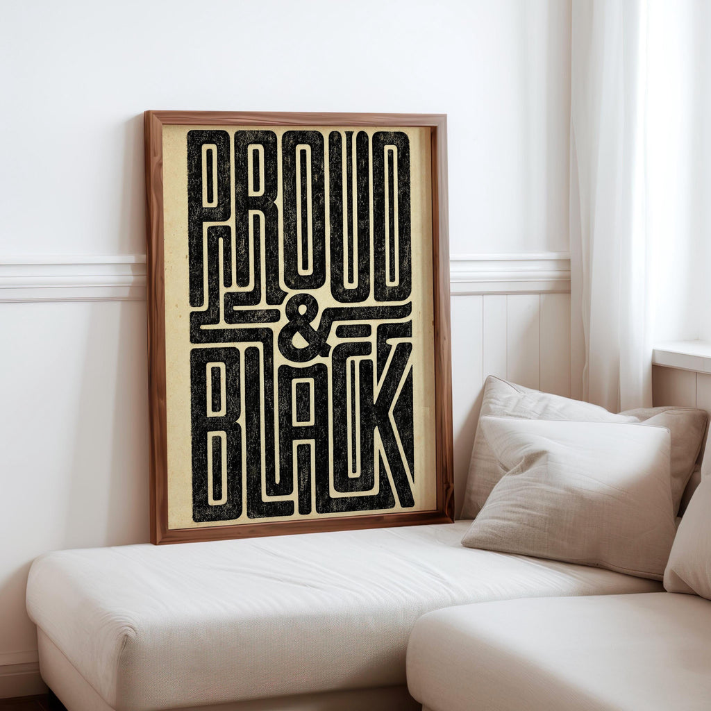 Neutral sitting nook with cushion and framed Proud and Black poster on low bench, bold statement wall art
