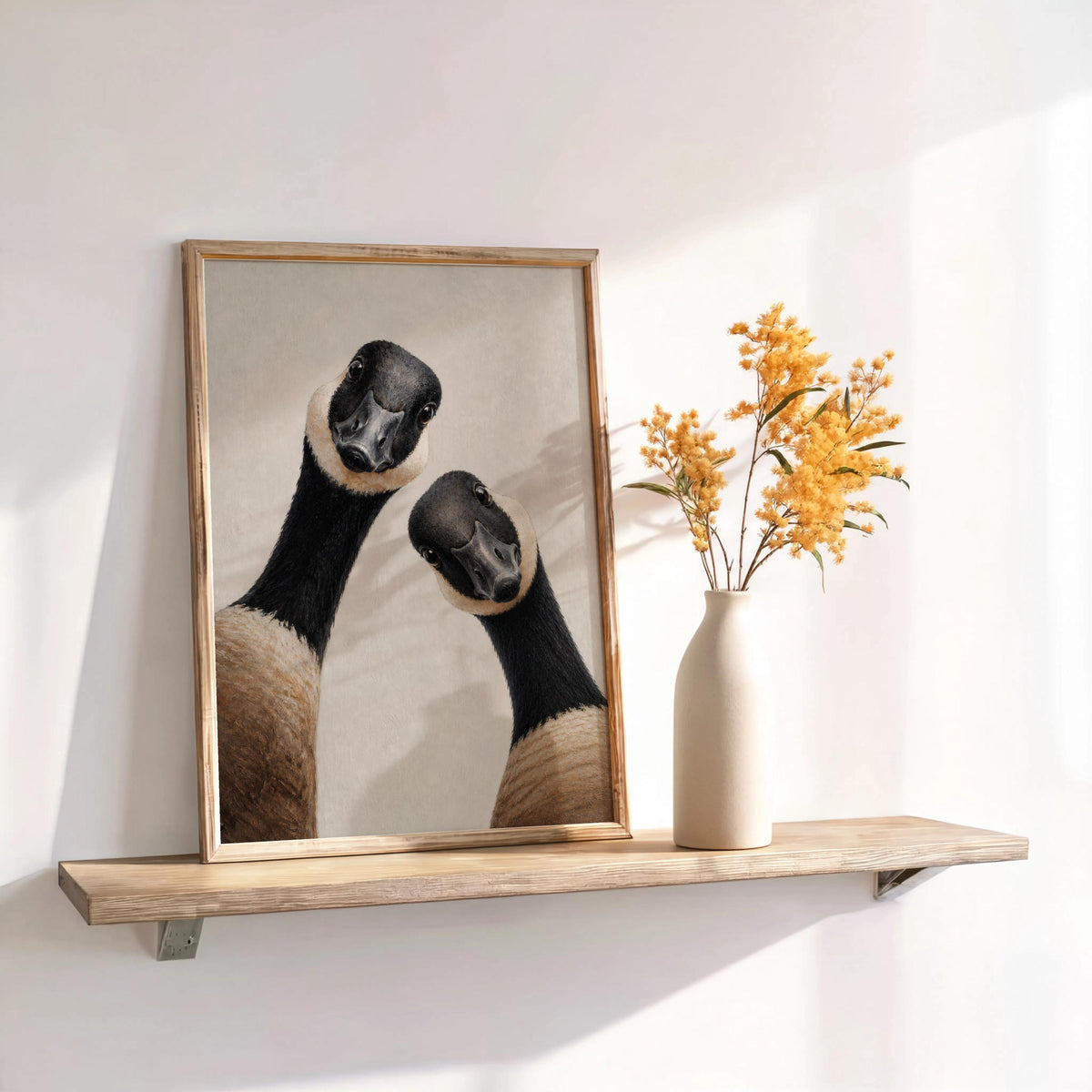 Canadian geese wall art beside dried flowers on a shelf, rustic wood frame, warm sunlight
