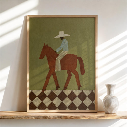 Framed abstract cowboy wall art leaning on a wooden shelf, olive background, rust horse and diamond border