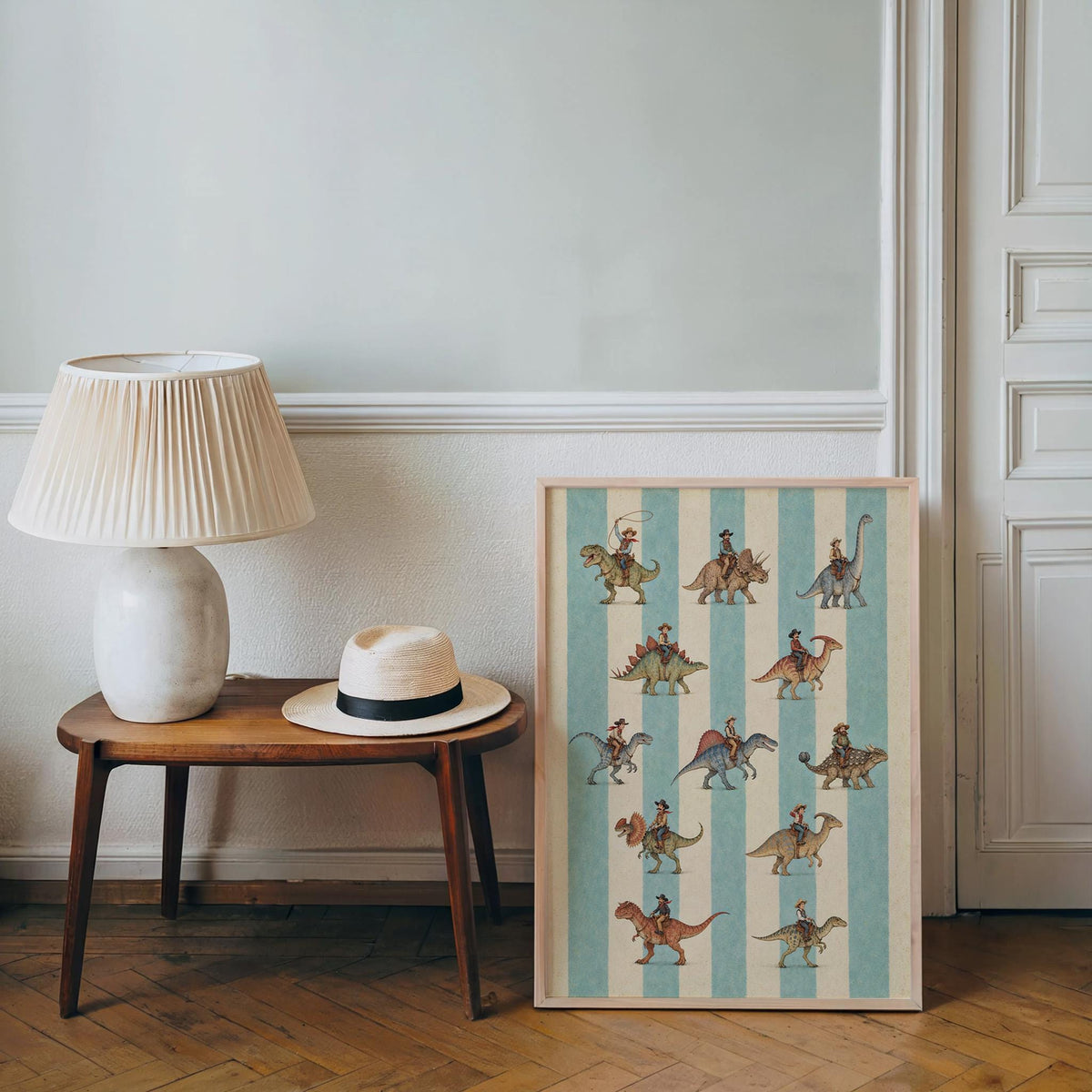 Cowboy dinosaur art print propped beside a lamp and table, cozy corner styling, dinosaur wall art accent