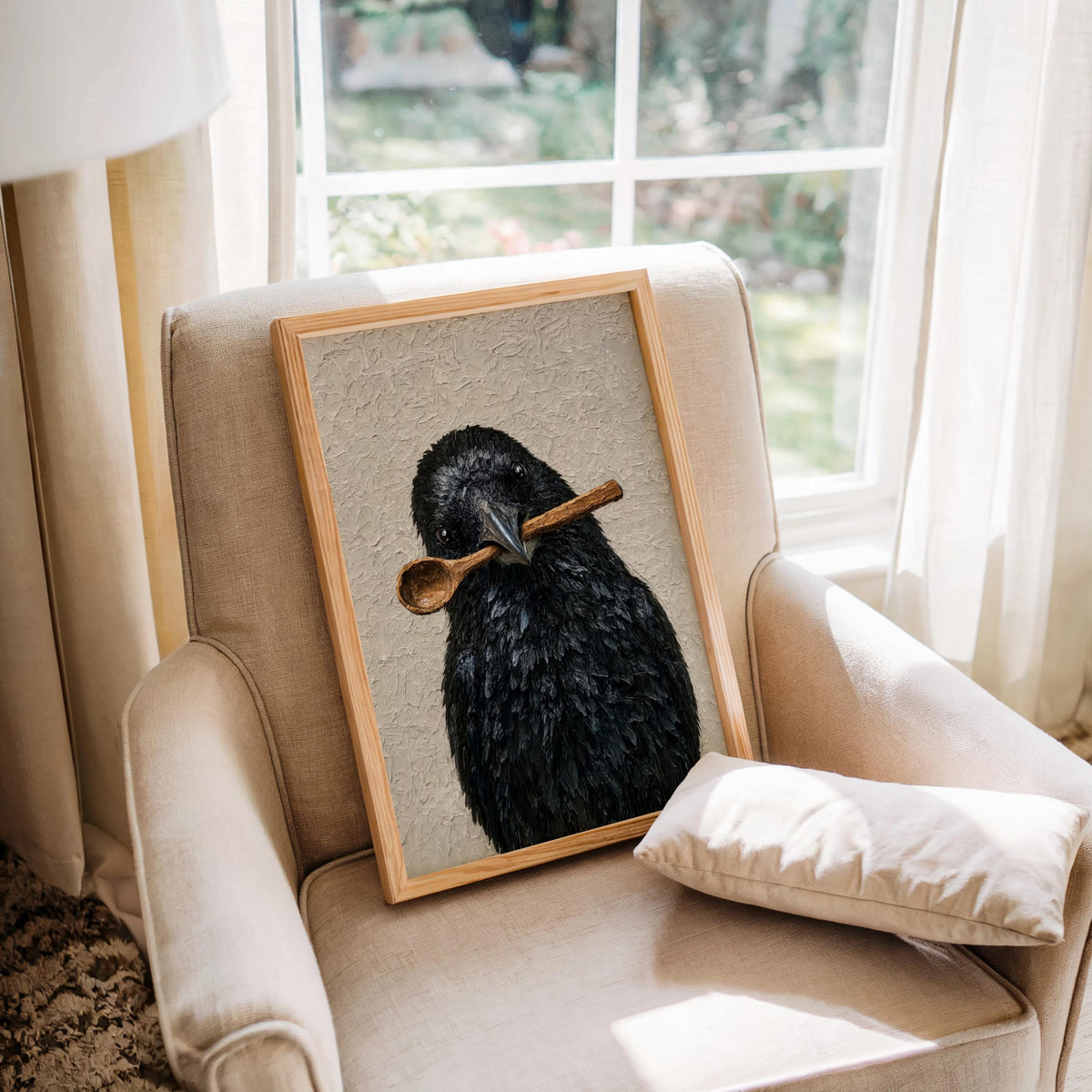 Funny crow wall art propped on an upholstered armchair by a window, textured print, creepy cute bird gift idea