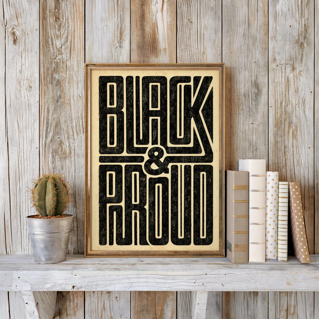 Black and Proud wall art leaning against reclaimed wood, potted cactus and stacked books, vintage paper texture, gold tones