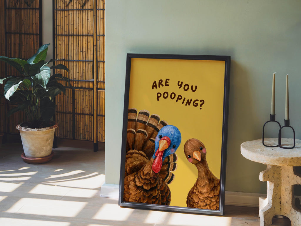 Powder room wall decor vignette, funny turkey bathroom print with yellow background leaning on floor, rustic plant and sunlight