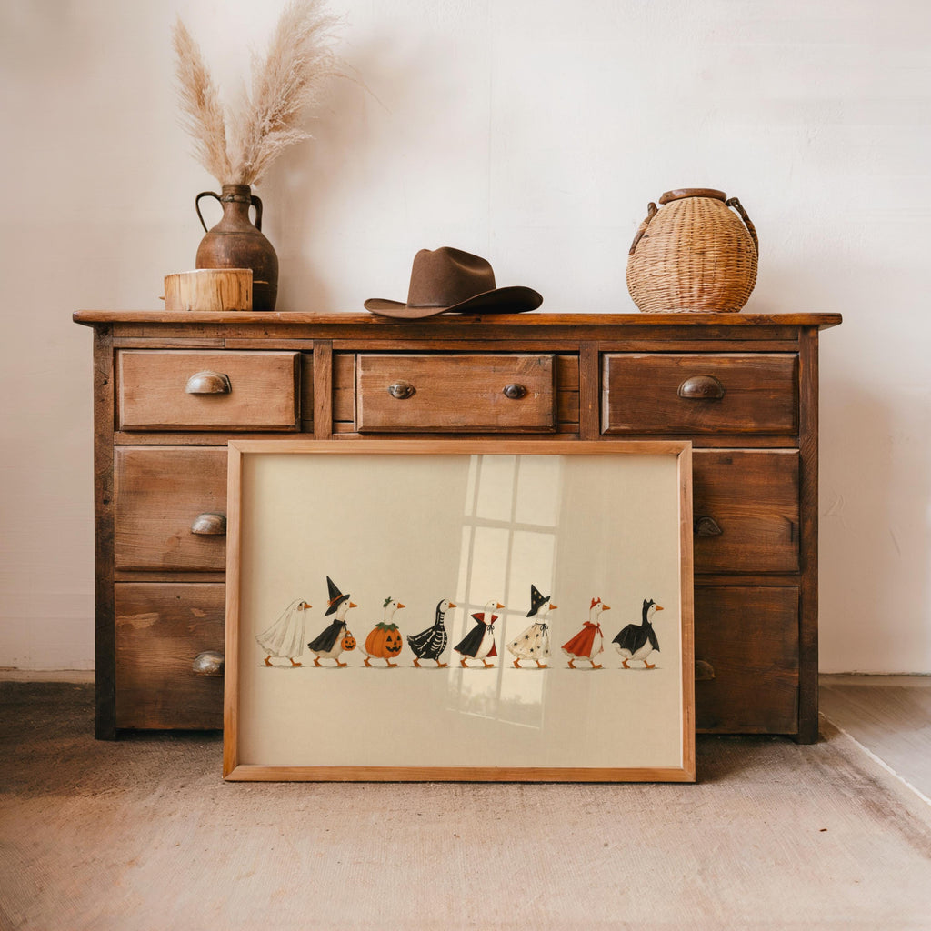 Rustic dresser vignette, vintage Halloween print propped below, cream paper, simple linework ducks