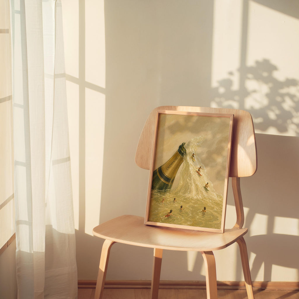 Small framed champagne bottle wall art on a wooden chair, sheer window light, warm cream and beige palette